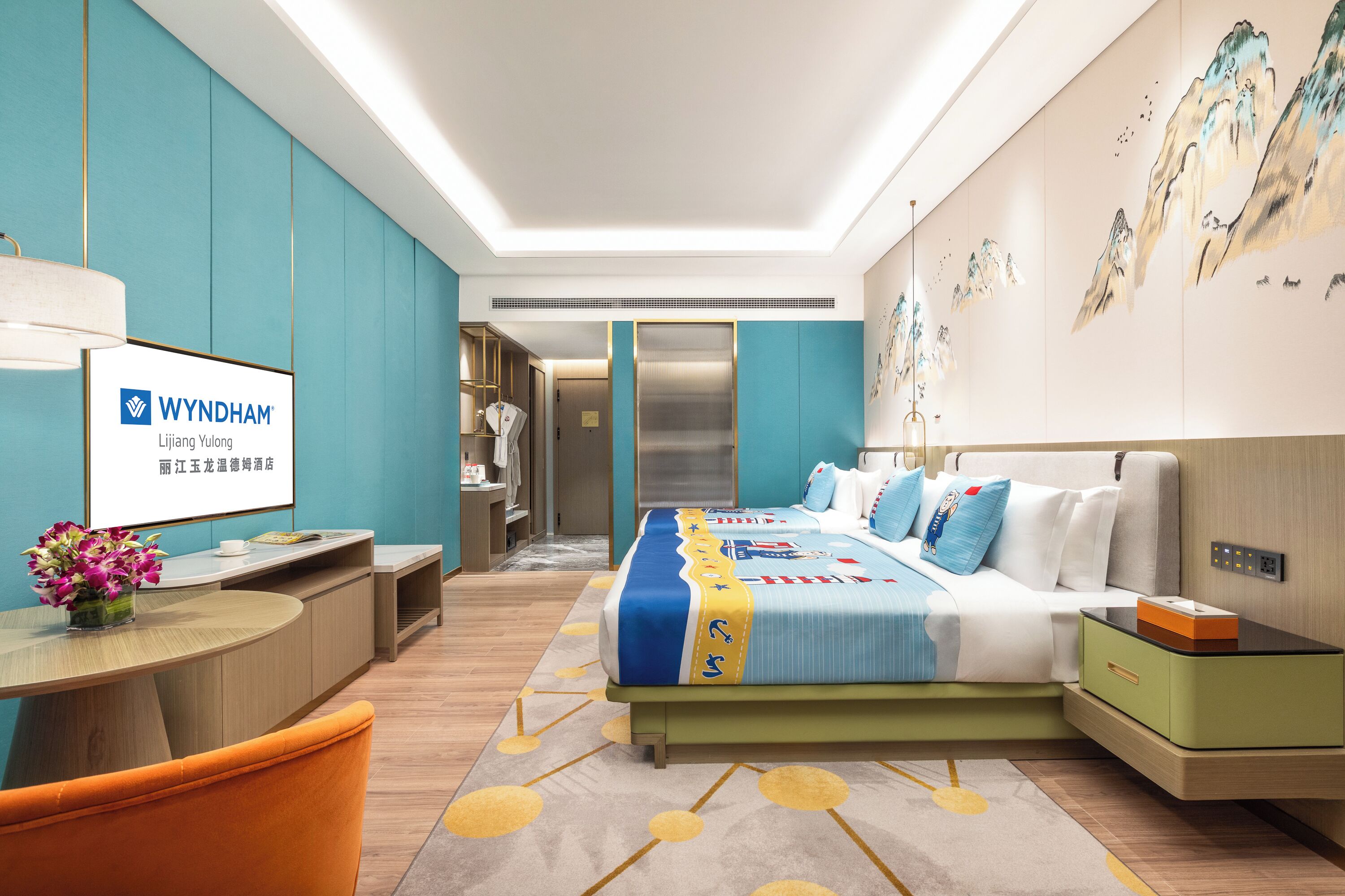 A hotel room with a bed, a desk, a chair, a bathroom, and a reception area.