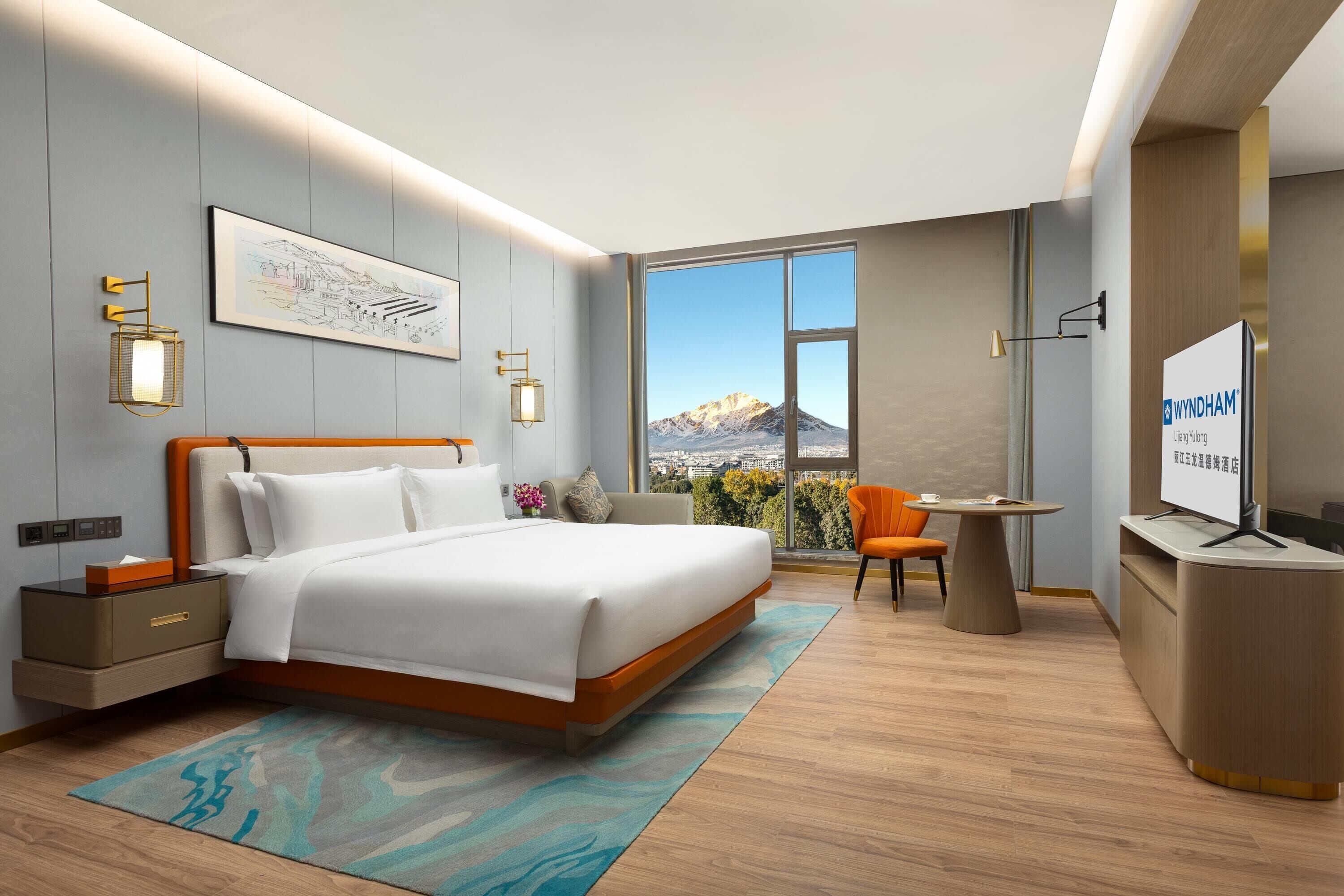A modern hotel room with a bed, bedside table, TV, and a desk with a chair.