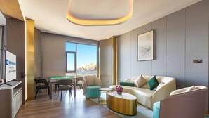 Een moderne hotelkamer met een pooltafel, een bank, een salontafel en een bureau.