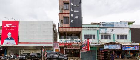 A building with a sign for 'Alex Hostel' and a 'J&T Express' advertisement.