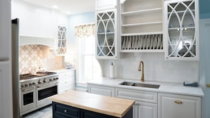 A kitchen with white cabinetry, a built-in stove, and a sink. - Historic Woodlawn Estate: Where Historic Charm meets Modern Luxury (Fraziers Bottom)