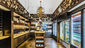 A narrow aisle with shelves on either side displaying various products, a central display case, and a Coca-Cola refrigerator on the right. - Epic 3-bed/3bth condo Next Door to Disney World (Orlando)