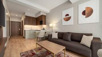 Una sala de estar moderna con un sofá, una mesa de centro y un comedor con sillas.
