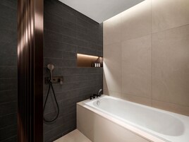 Un baño moderno con bañera, ducha y tocador con espejo.