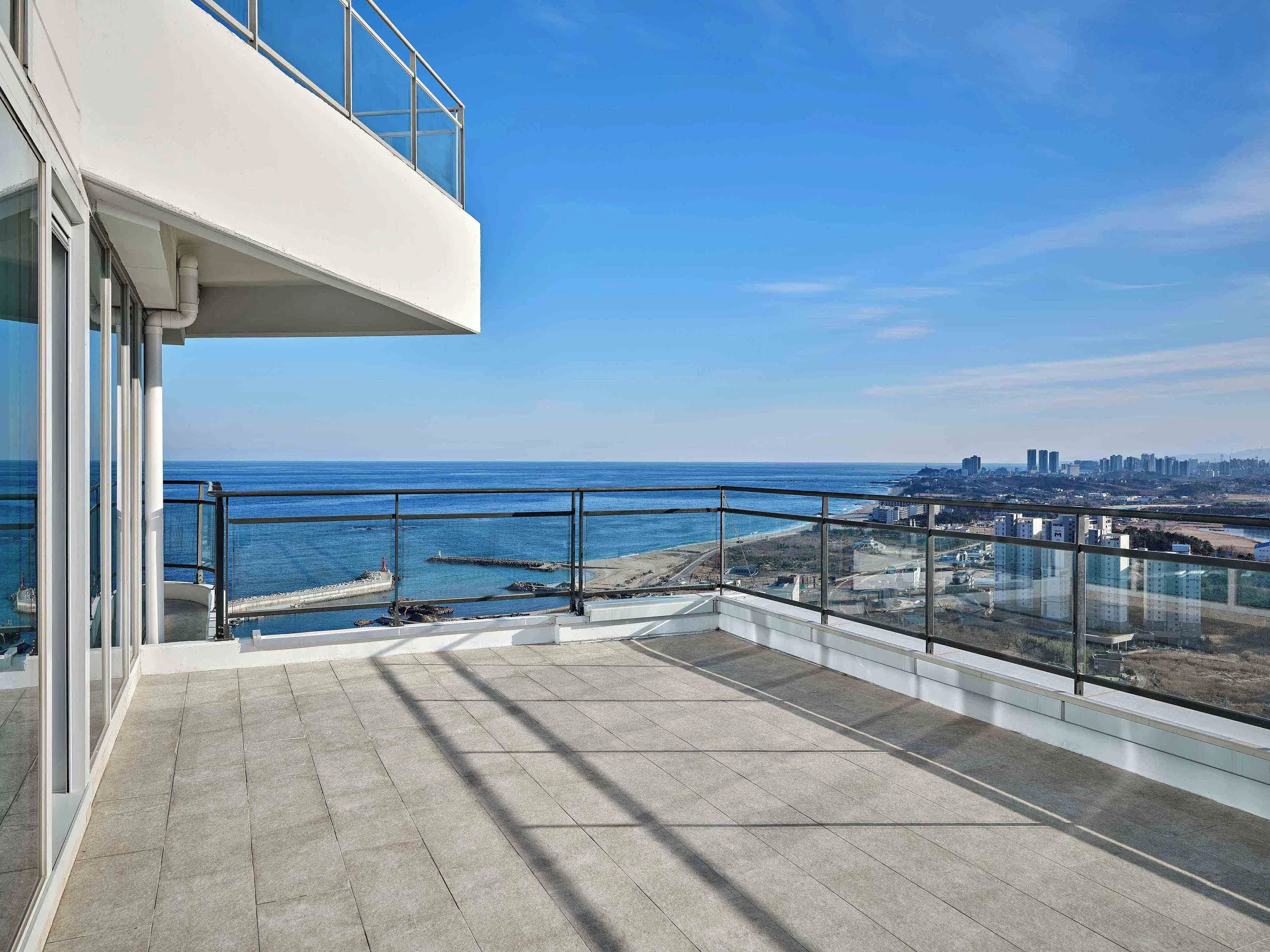 Ein Balkon mit Blick auf das Meer und die Stadt.