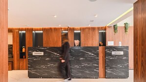 A reception area with marble counters labeled 'CONCIERIE' and 'RECEPTION,' wooden paneling, and a plant. - Boutique Hotel Aruba Casablanca (Casablanca)