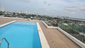 A rooftop swimming pool with a city view, surrounded by glass railings and a brick deck. - Mirador Baluarte Pool& Parking (Cartagena de Indias)