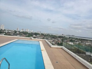 A rooftop swimming pool with a city view, surrounded by glass railings and a brick deck. - Mirador Baluarte Pool& Parking (Cartagena de Indias)