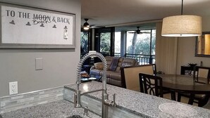Eine Küche mit Granit Arbeitsplatte, Spüle aus Edelstahl und einem Essbereich mit Tisch und Stühlen.