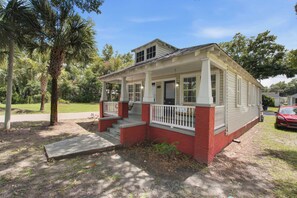 A single-story house with a porch, a garage, and a driveway. - Charming Charleston Bungalow Near Park Circle (North Charleston)