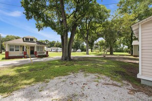 A residential area with a house featuring a porch and a garage. - Stylish Bungalow Stay Near Downtown Charleston (North Charleston)