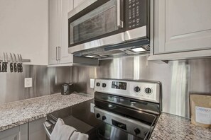 A kitchen with stainless steel appliances, including a microwave, oven, and toaster. - Stylish Bungalow Stay Near Downtown Charleston (North Charleston)
