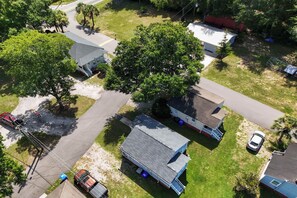 A residential area with multiple houses, a paved driveway, and a large tree. - Quiet Retreat Near Downtown Charleston (North Charleston)