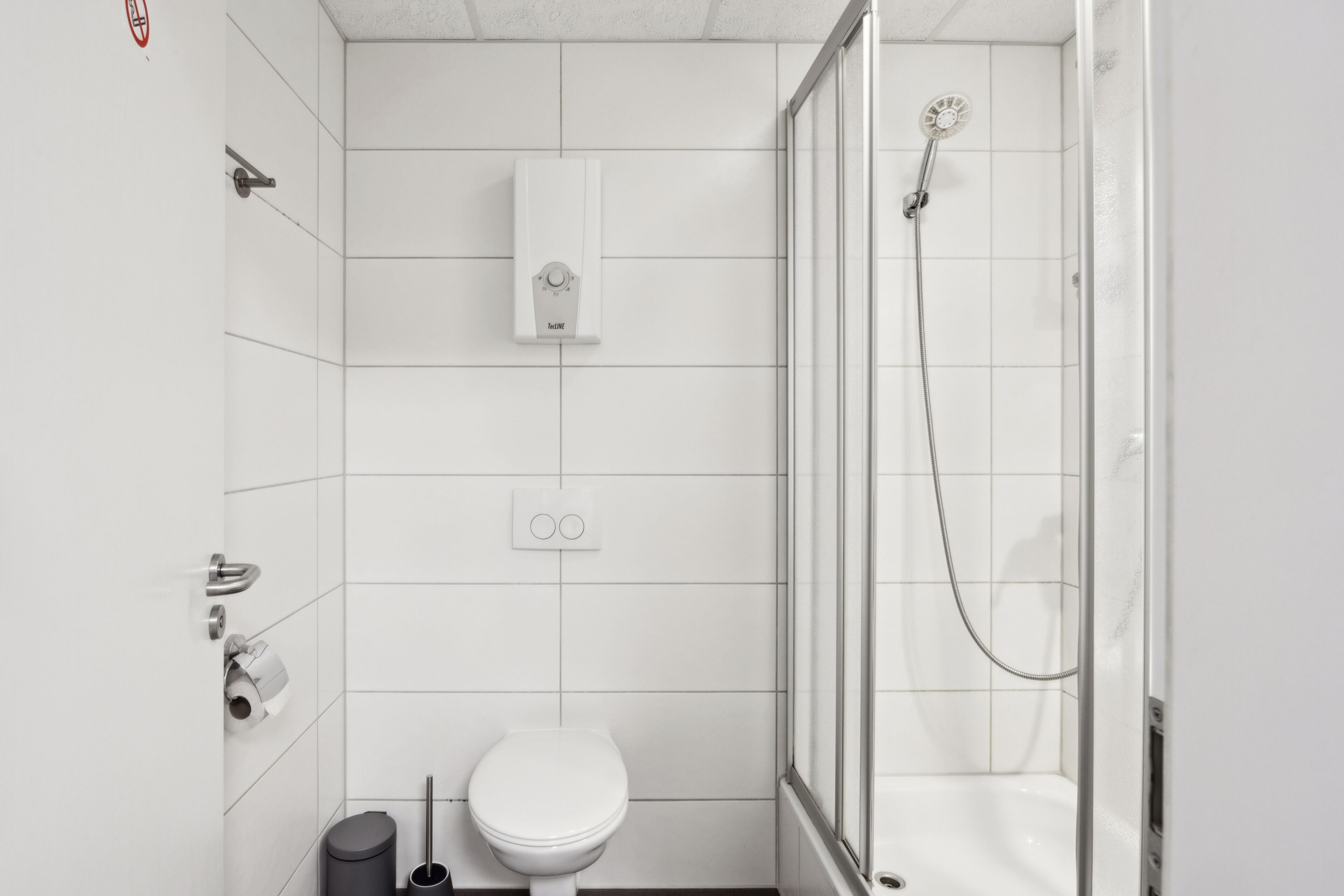 Un baño moderno con inodoro, ducha y toallero.