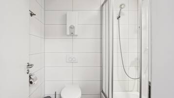 Un baño moderno con inodoro, ducha y toallero.