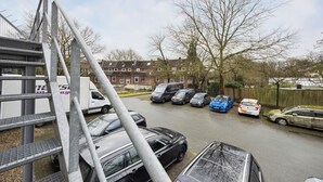 A parking lot with several cars, a metal structure, and residential buildings in the background. - HanseStay Wandsbek (Hamburg)