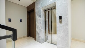 A modern elevator with marble walls and a digital display. - Luxury two bedroom Apartment Al Rawdha (Riyadh)