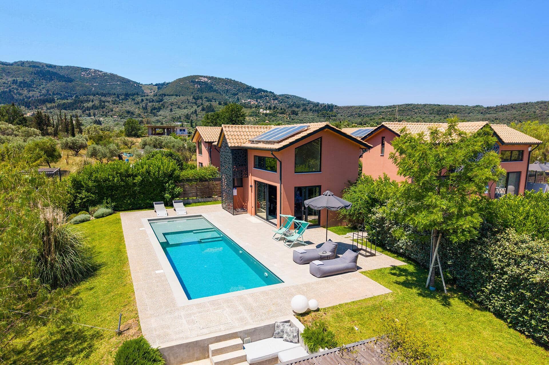 A residential property with a swimming pool, outdoor seating, and a view of the surrounding hills.