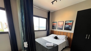 A hotel room with a bed, a wardrobe, a window with curtains, and three landscape paintings on the wall. - Apt w/ Partial Sea View 350m From the Beach Hpa904 (Salvador)