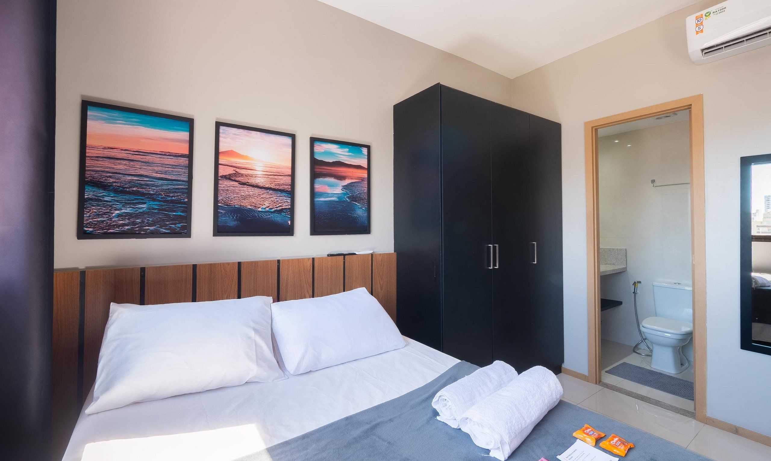 A hotel room with a bed, a wardrobe, and a bathroom.