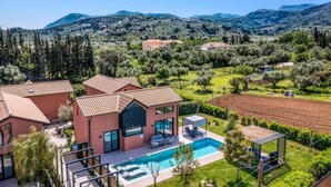 A modern villa with a swimming pool, surrounded by olive groves and mountains. - Villa Water by Villa Plus (Kariotes)