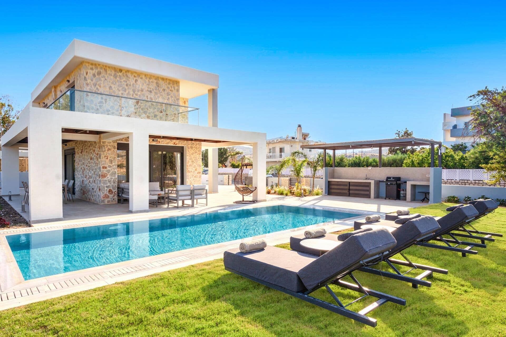 A modern house with a swimming pool, outdoor seating, and a barbecue area.