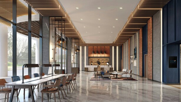 Eine geräumige Lobby mit einer langen Rezeption, einer Sitzecke und einer modernen Küche im Hintergrund.