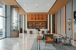 A modern lobby with a reception desk, seating area, and a display of items. - Four Points By Sheraton Nha Trang (Nha Trang)