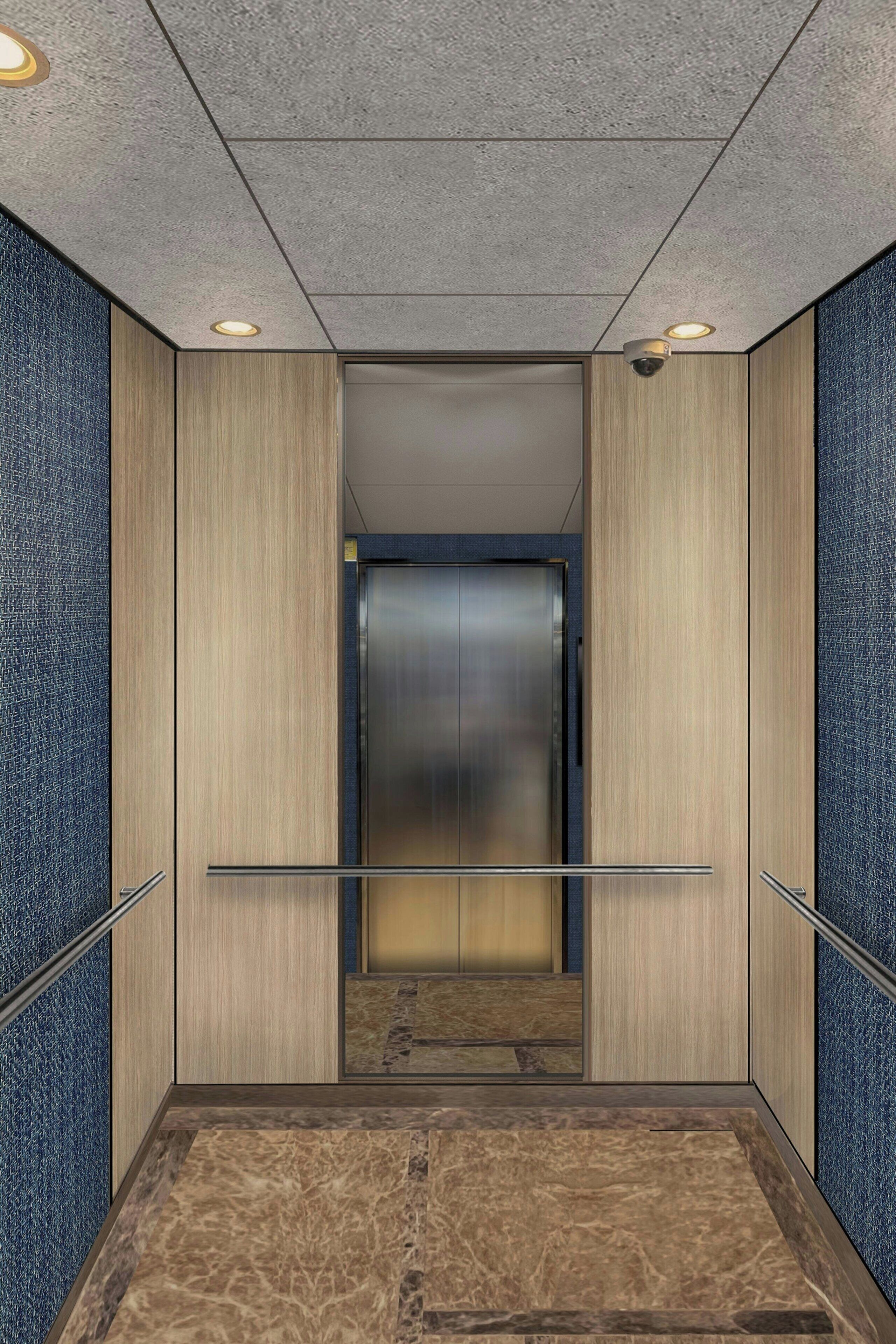 An elevator with a metallic door, wooden paneling on the walls, and a marble floor.