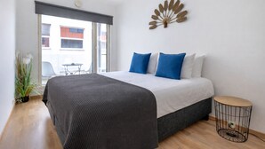 A modern bedroom with a large bed, a small round table, and a decorative wall piece. - City center with Free parking and Sauna (Tallinn)