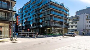 A multi-story building with balconies, a visible entrance, and a car parked in front. - City center with Free parking and Sauna (Tallinn)