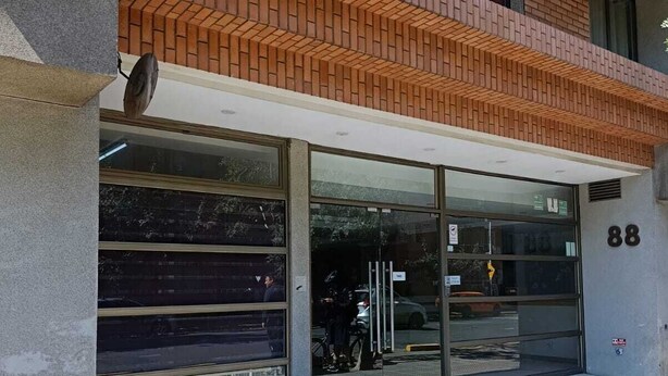 A building with a brick facade, large glass windows, and a sign displaying the number 88. - Central apartment/studio family friends and couples (Santiago)
