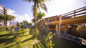 A hotel with a pool, outdoor seating, and a playground. - Hotel Cia do Mar (Bertioga)
