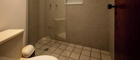 A modern bathroom with a glass-enclosed shower, a toilet, and a sink.