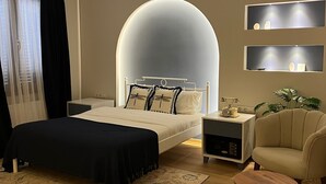 A modern bedroom with a large bed, bedside tables, a chair, and a unique ceiling feature.