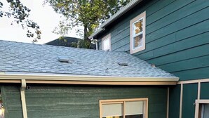 A green building with a gravel driveway and a wooden bench. - Centrally Located Basement Apartment, Newly Remodeled, Pets Welcome (Missoula)