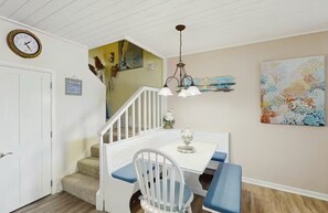 A dining nook with corner bench seating set beneath an interior staircase. - Cozy Coastal Escape | Pool, Bay Views, Beaches (Selbyville)