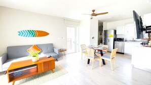 Een moderne woonkamer met een bank, salontafel en een eethoek.