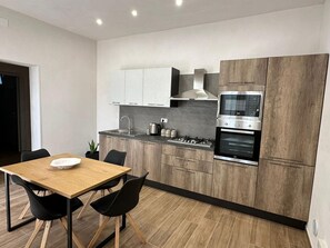 Apartamento Deluxe | Cocina privada | Frigorífico, microondas, horno y placa de cocina