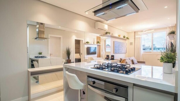 A modern kitchen with a central island, built-in appliances, and a dining area with a TV and seating. - Condominium With Pool in Downtown Florianopolis - Cjos (Florianópolis)
