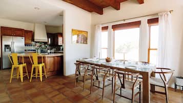 A kitchen with a large island, wooden cabinets, and yellow chairs.