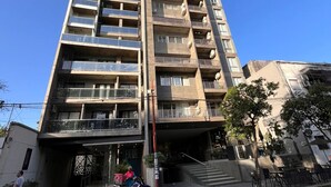 A tall, multi-story building with balconies and a ground-level entrance. - Back to the Neighborhood - Luminous Studio in South Neighborhood with Pool (San Miguel de Tucumán)