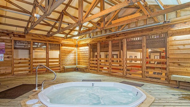 A wooden cabin with a hot tub, wooden walls, and a sloped ceiling. - 2 Br: Snowcrest 214a 2 Bedroom: Indoor Hot Tubs Game Room Easy Slope Access (Snowshoe)