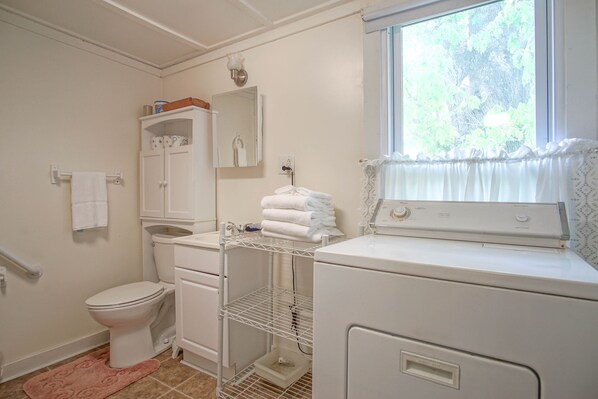 Ein kleines, sauberes Badezimmer mit Toilette, Waschbecken und Fenster.