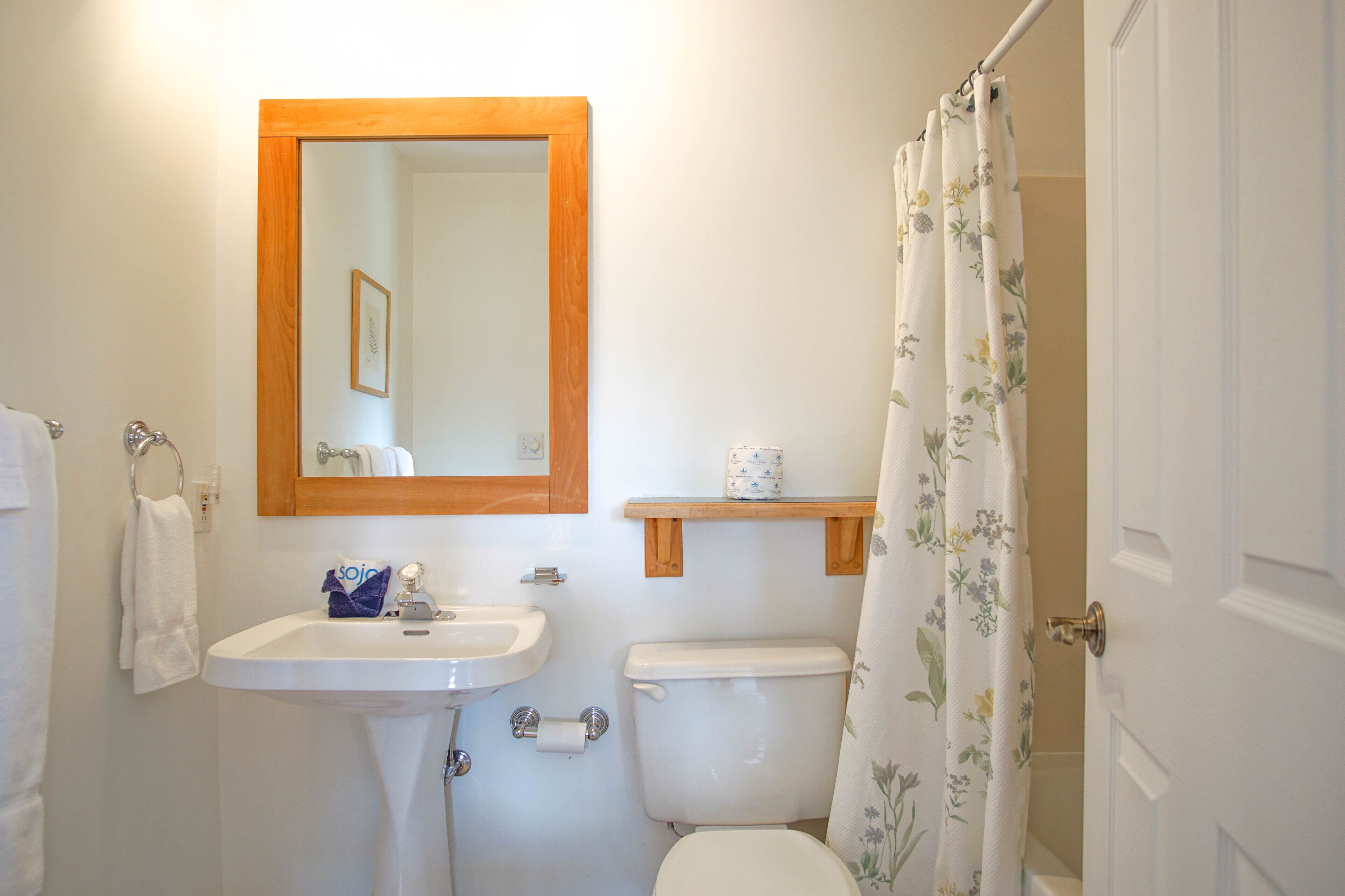 Une salle de bain avec un lavabo, des toilettes et un miroir.