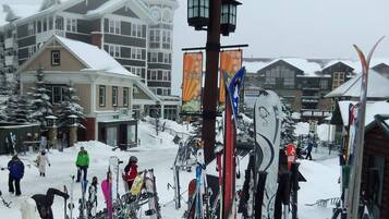 A snowy ski resort with multiple buildings, including a lodge with a clock tower.