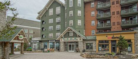 A hotel with a stone facade, multiple balconies, and a central entrance.