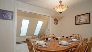 A dining room with a wooden table set for six, surrounded by six wooden chairs. - Leatherbark - 202a 2 BR Condo Spacious Living Room (Snowshoe)