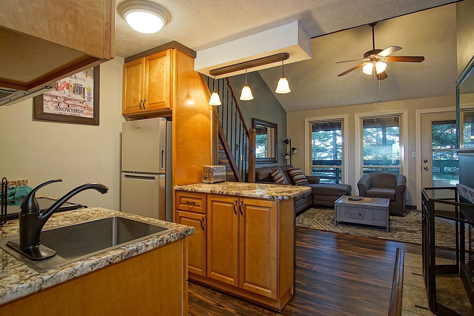 A spacious kitchen with wooden cabinets, a built-in island, and a large refrigerator.