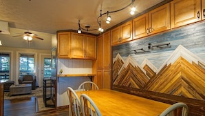 Una cocina con armarios de madera, una mesa de comedor y sillas.